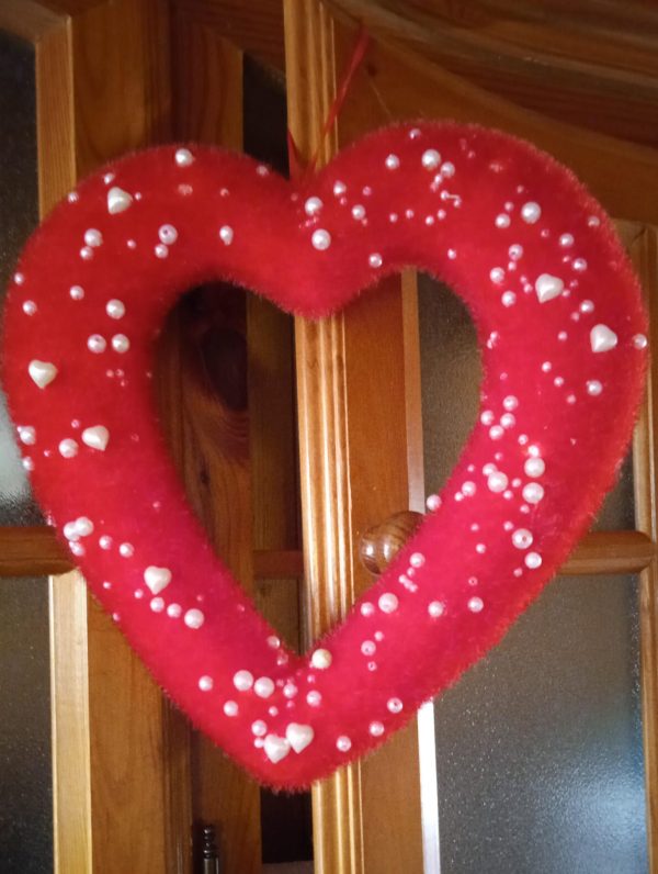 Cuore tempestato di perline e cuoricini bianchi